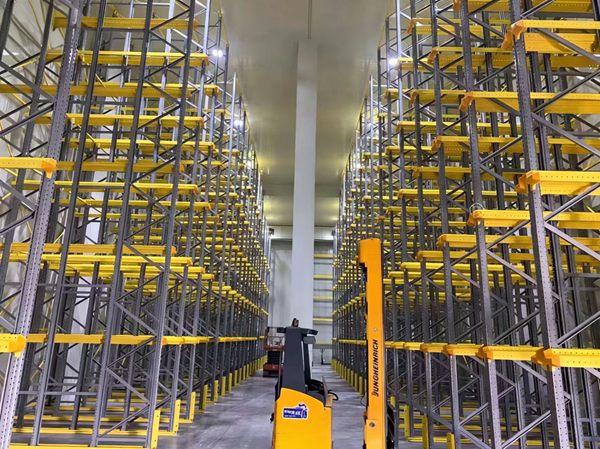High-density pallet racking system with narrow forklift aisles in a warehouse. High-density pallet racking system with narrow forklift aisles in a warehouse.